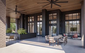 a patio area with tables and chairs and large windows at Preston Ridge, Cary